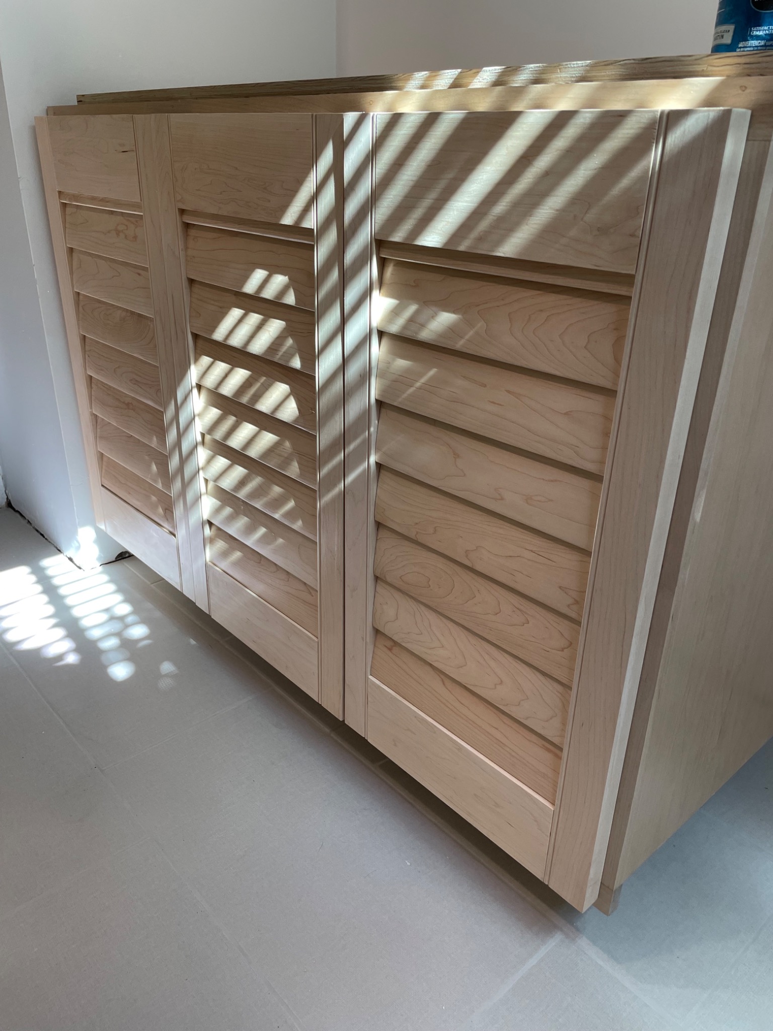 Custom handcrafted wood vanity with louvered doors and concealed drawers